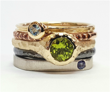 Stacking rings with Peridot, orange diamonds, sapphire, Aquamarine, and different colors of gold and sterling silver